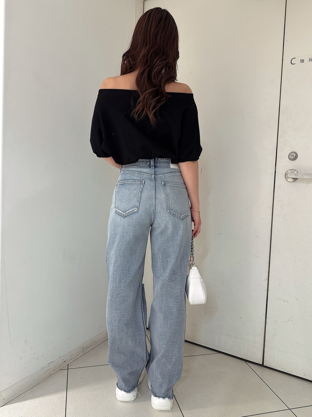 ブラック系のTシャツ/カットソー、ブルー系のデニムパンツ、ホワイト系のスニーカーを着用したレディースの春コーディネートの3枚目の写真