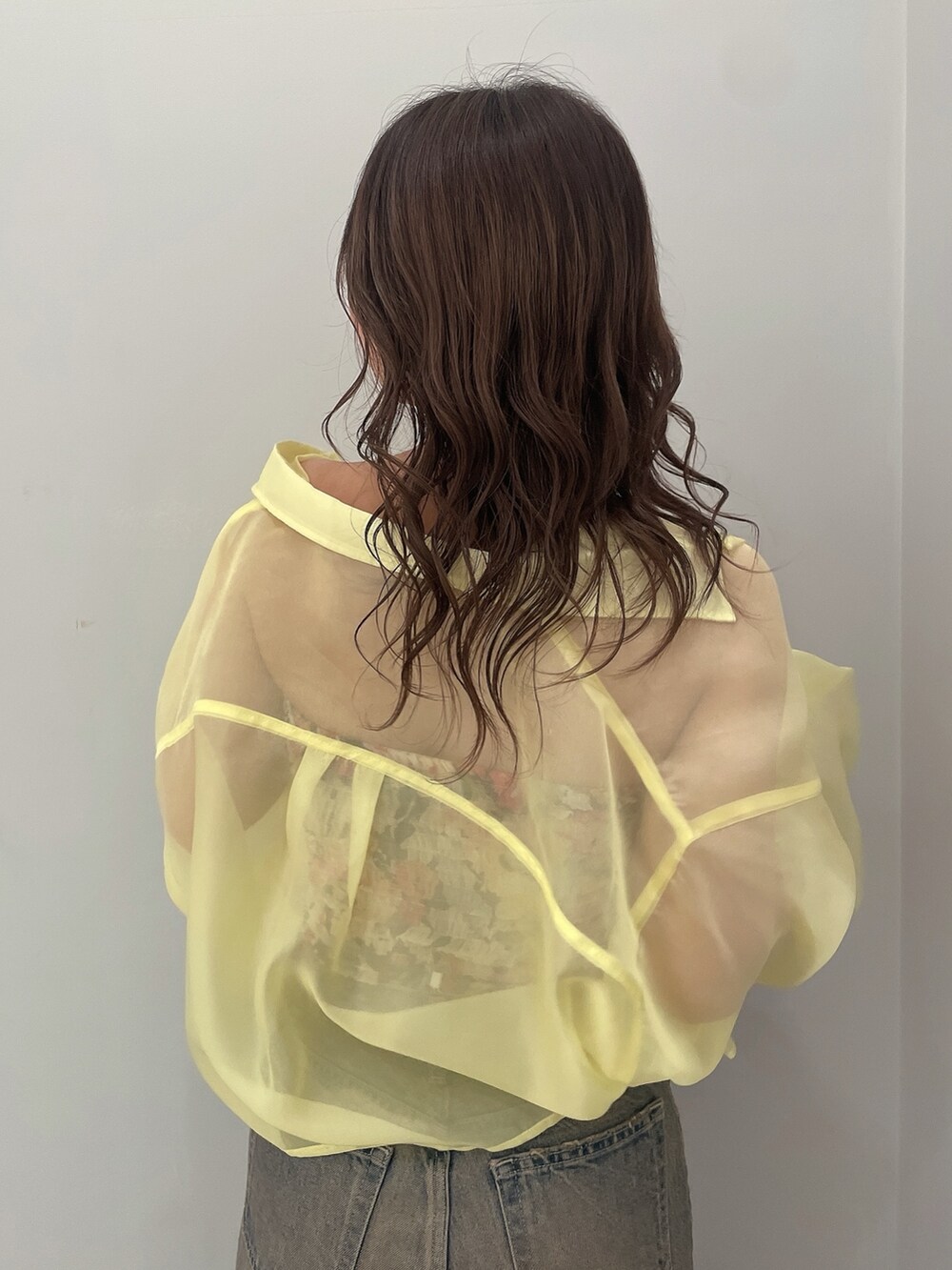 イエロー系のシャツ/ブラウス、ブラック系のチューブトップ、ブルー系のデニムパンツを着用したレディースの春コーディネートの6枚目の写真