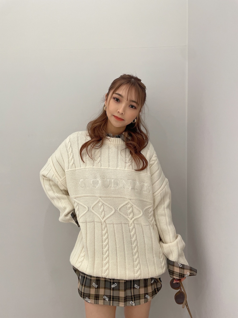 ベージュ系のシャツ/ブラウス、ホワイト系のニット/セーター、ブラック系のスカートを着用したレディースの冬コーディネートの3枚目の写真