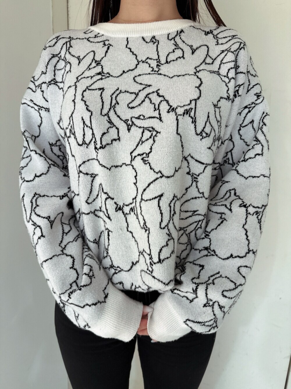 ブラック系のデニムパンツ、ブラック系のブーツ、ホワイト系のニット/セーターを着用したレディースの冬コーディネートの7枚目の写真