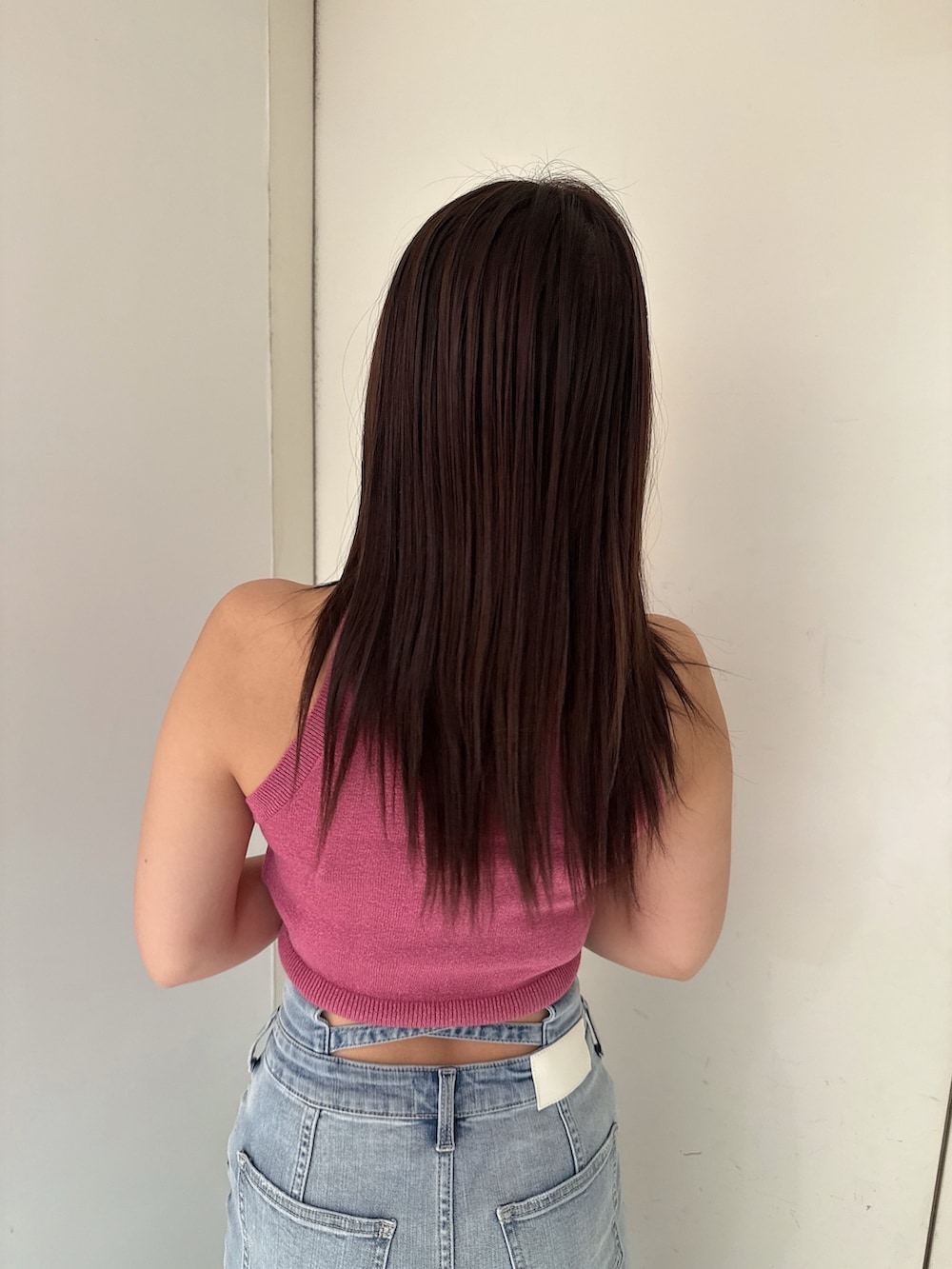 ピンク系のニット/セーター、ブルー系のデニムスカート、ホワイト系のサンダルを着用したレディースの夏コーディネートの6枚目の写真