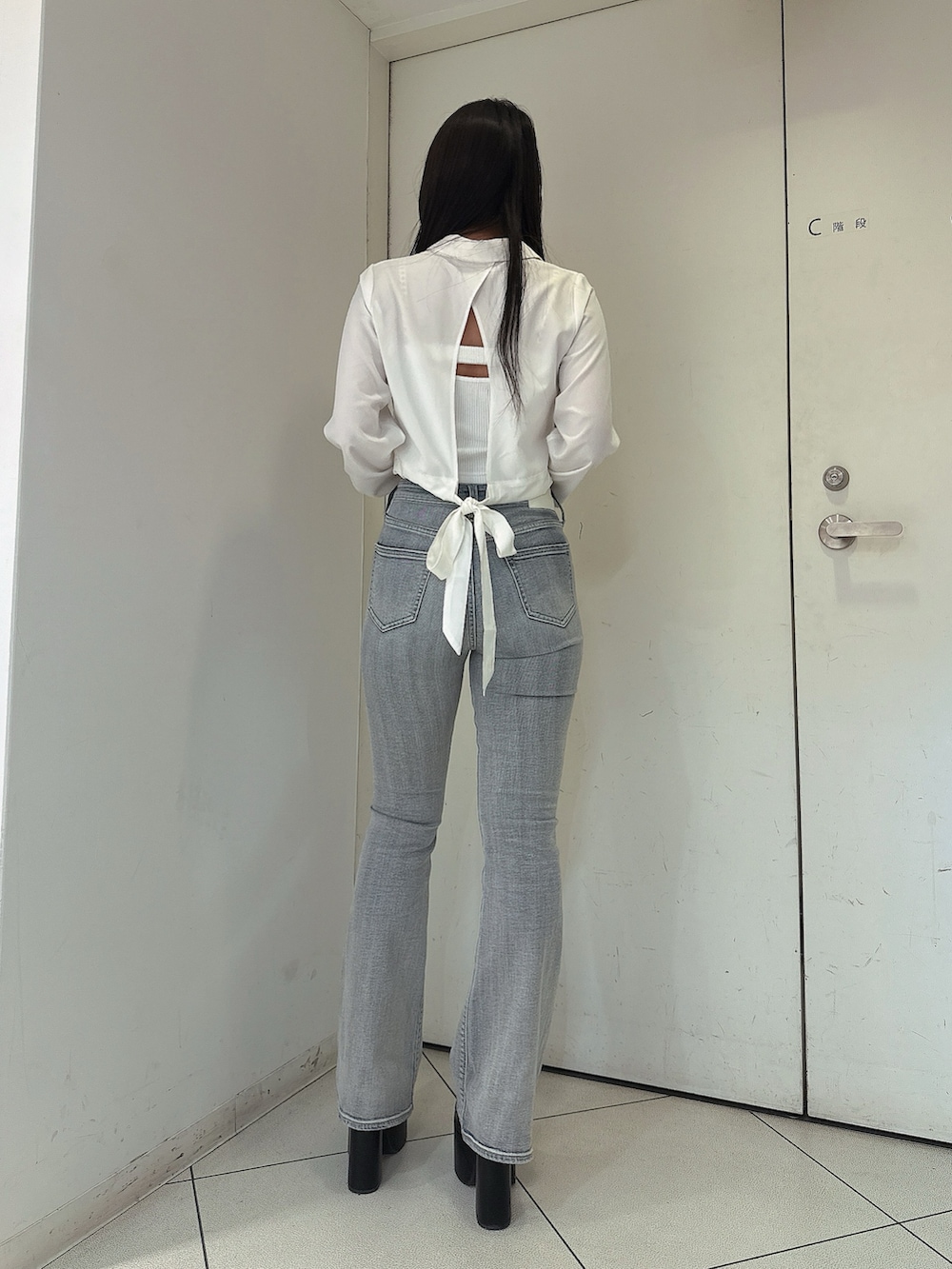 ブルー系のデニムパンツ、ホワイト系のキャミソール、ホワイト系のシャツ/ブラウスを着用したレディースの春コーディネートの3枚目の写真