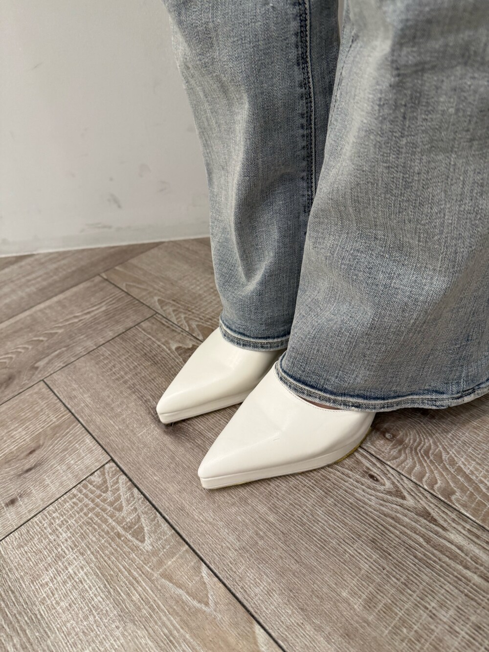 ブルー系のデニムパンツ、ホワイト系のパンプス、ホワイト系のスウェットを着用したレディースの冬コーディネートの8枚目の写真