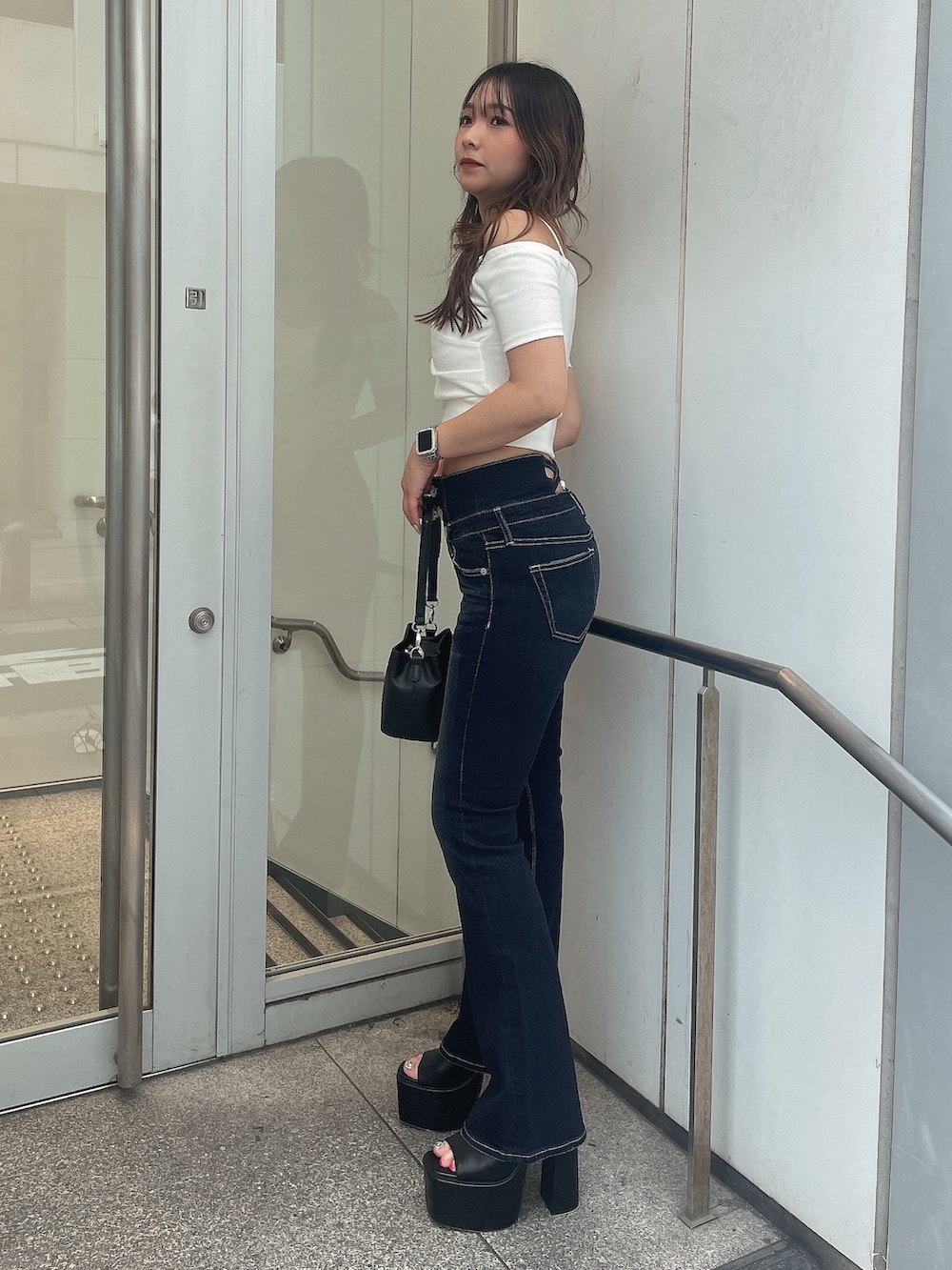 ホワイト系のTシャツ/カットソー、ブルー系のデニムパンツ、ブラック系のショルダーバッグを着用したレディースの夏コーディネートの2枚目の写真