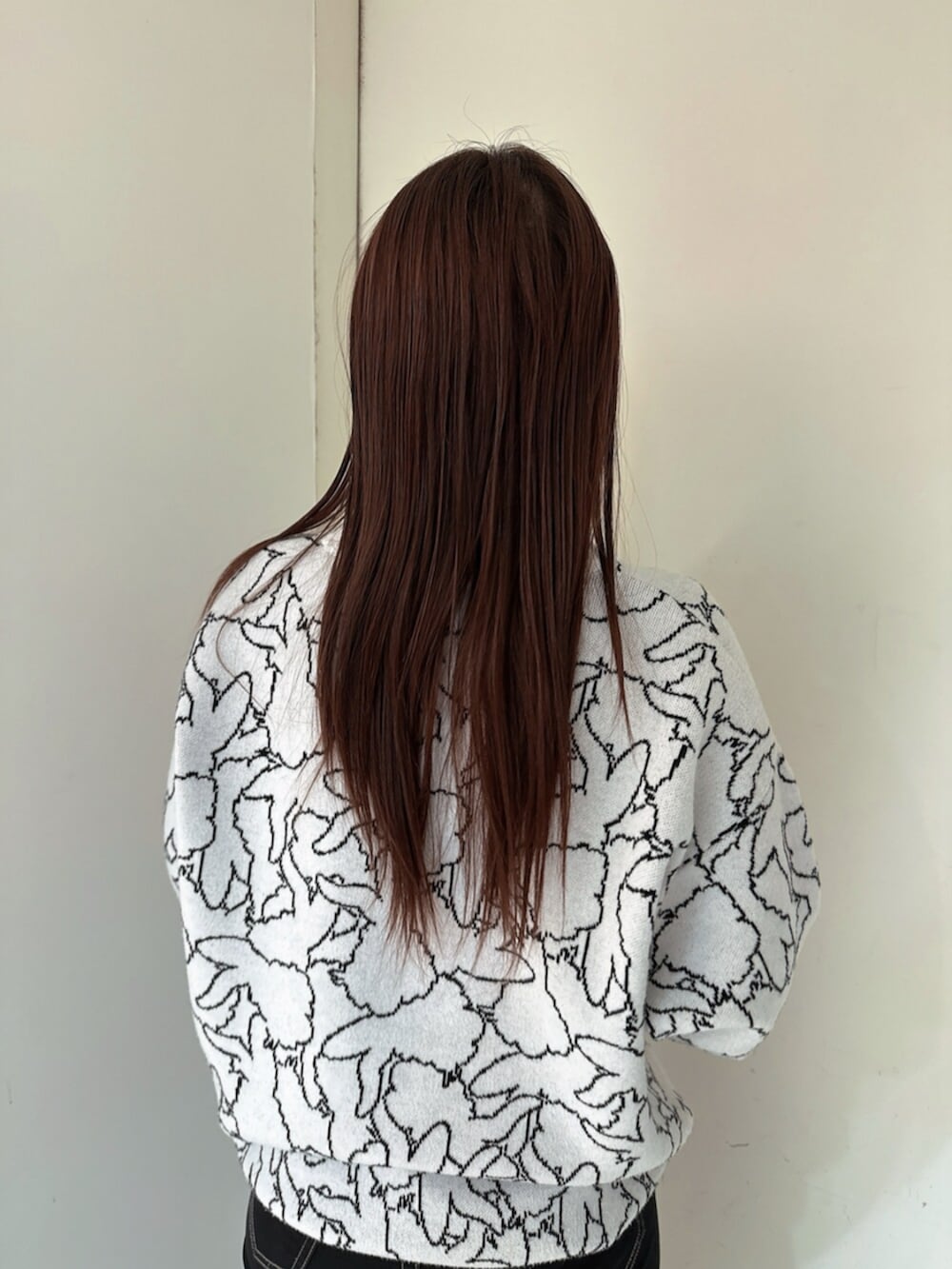 ブラック系のデニムパンツ、ブラック系のブーツ、ホワイト系のニット/セーターを着用したレディースの冬コーディネートの6枚目の写真