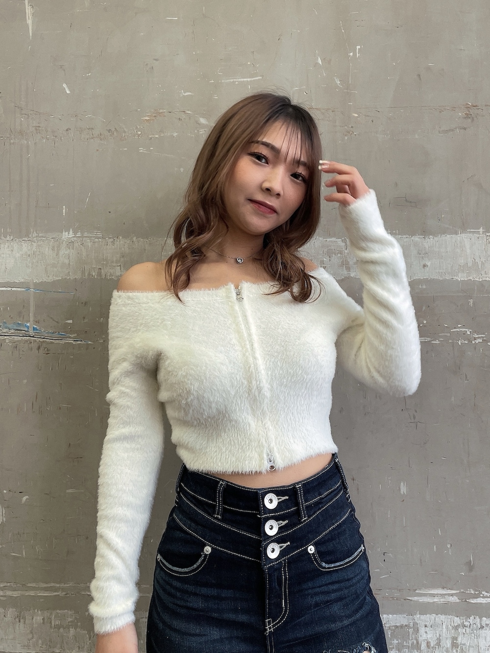 ホワイト系のブルゾン、ホワイト系のニット/セーター、ブルー系のデニムパンツを着用したレディースの冬コーディネートの7枚目の写真