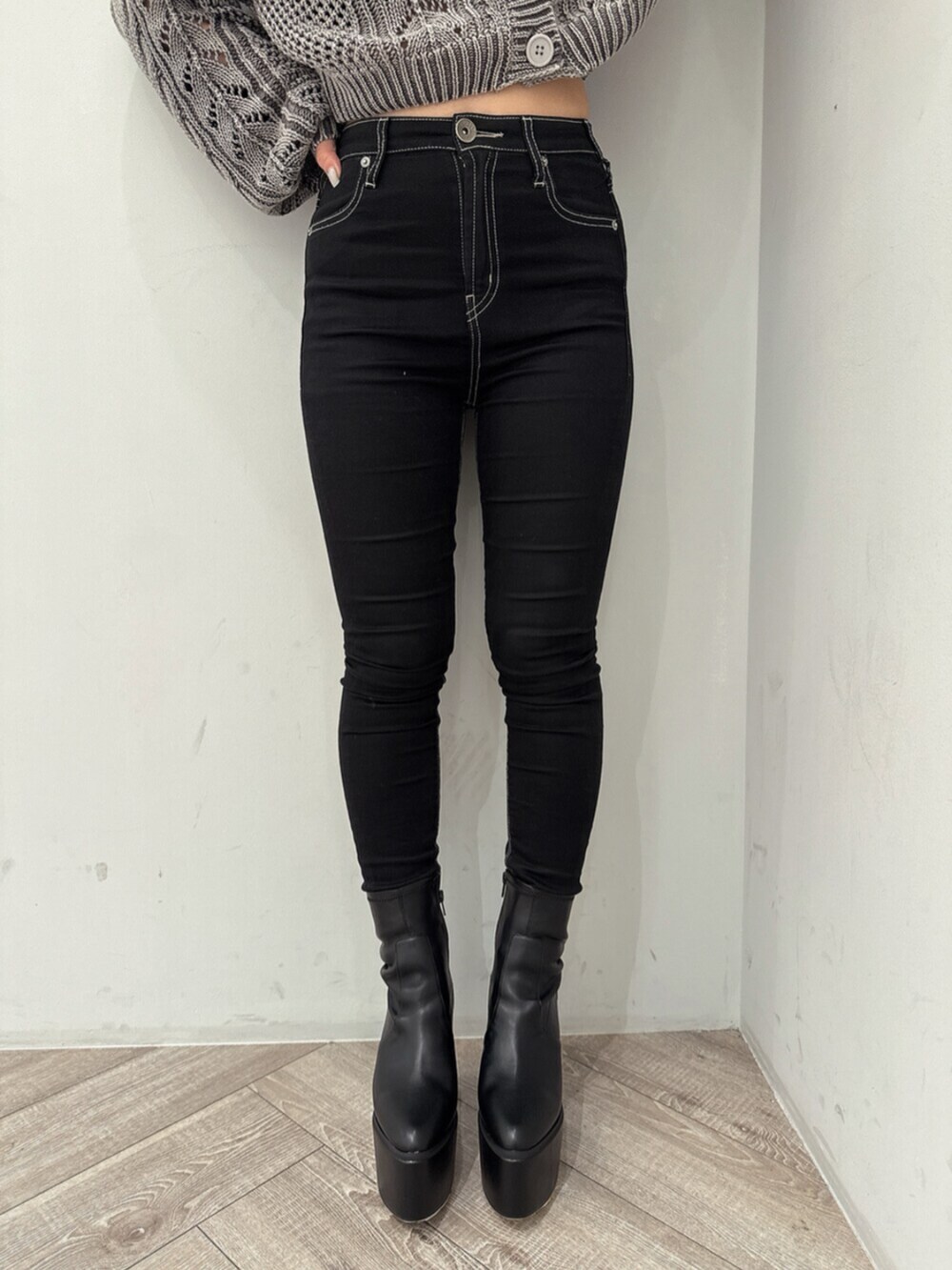 ブラック系のデニムパンツ、ホワイト系のスウェット、ブラック系のブーツを着用したレディースの夏コーディネートの7枚目の写真