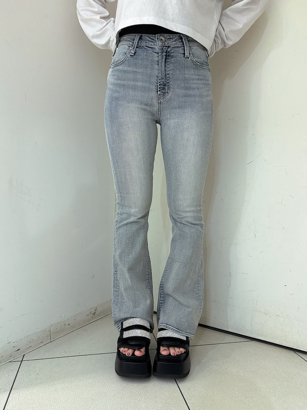 ブルー系のデニムパンツ、ホワイト系のTシャツ/カットソー、ブラック系のサンダルを着用したレディースの春コーディネートの8枚目の写真