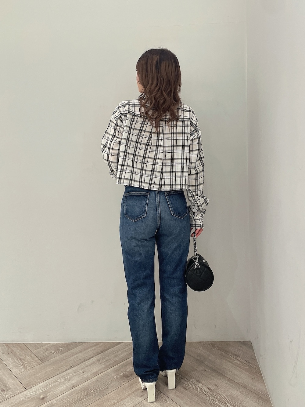 ホワイト系のシャツ/ブラウス、ブルー系のデニムパンツ、ブラック系のハンドバッグを着用したレディースの春コーディネートの3枚目の写真