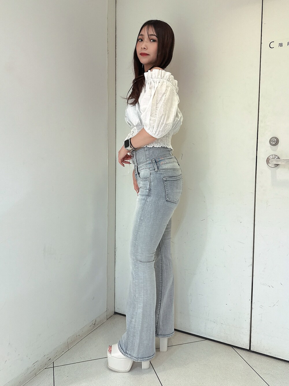 ブルー系のデニムパンツ、ホワイト系のシャツ/ブラウス、ホワイト系のサンダルを着用したレディースの春コーディネートの2枚目の写真