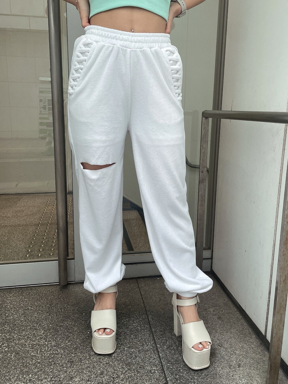 グリーン系のTシャツ/カットソー、ホワイト系のその他パンツ、ホワイト系のサンダルを着用したレディースの春コーディネートの8枚目の写真