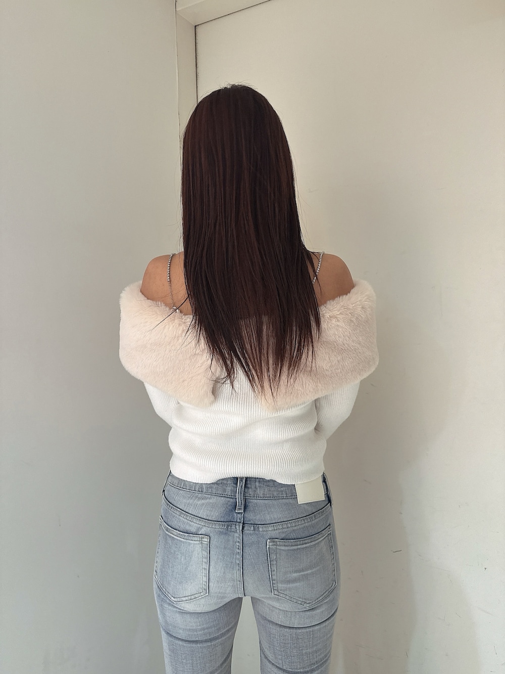 ホワイト系のニット/セーター、ブルー系のデニムパンツ、ブラック系のブーツを着用したレディースの秋コーディネートの6枚目の写真