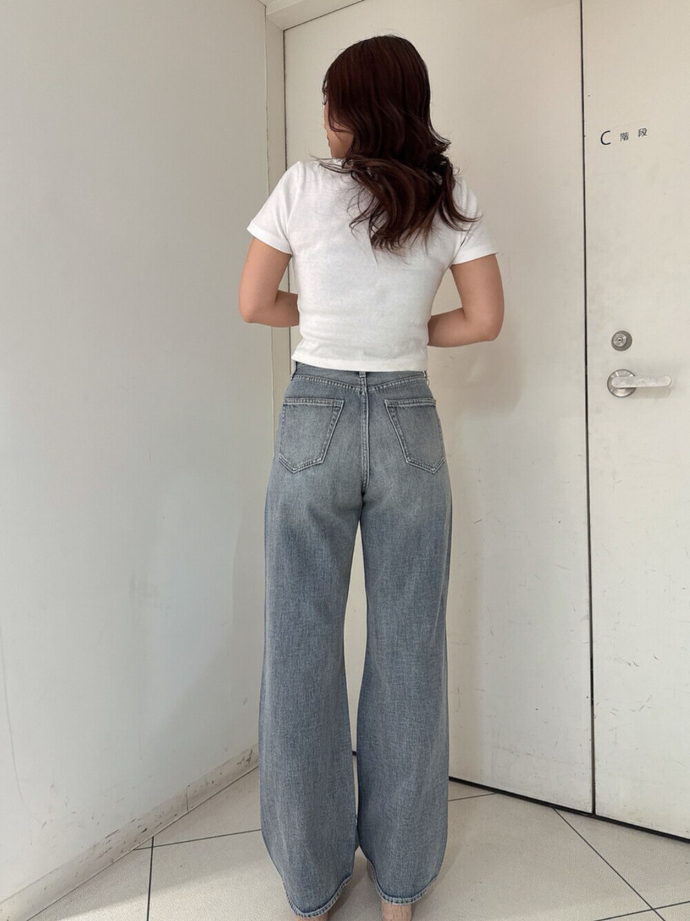 ホワイト系のサンダル、ホワイト系のTシャツ/カットソー、ブルー系のデニムパンツを着用したレディースの春コーディネートの3枚目の写真