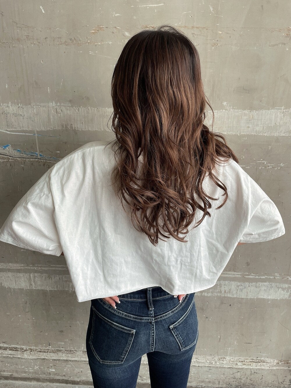 ホワイト系のTシャツ/カットソー、ブラック系のキャミソール、ブルー系のデニムパンツを着用したレディースの夏コーディネートの6枚目の写真