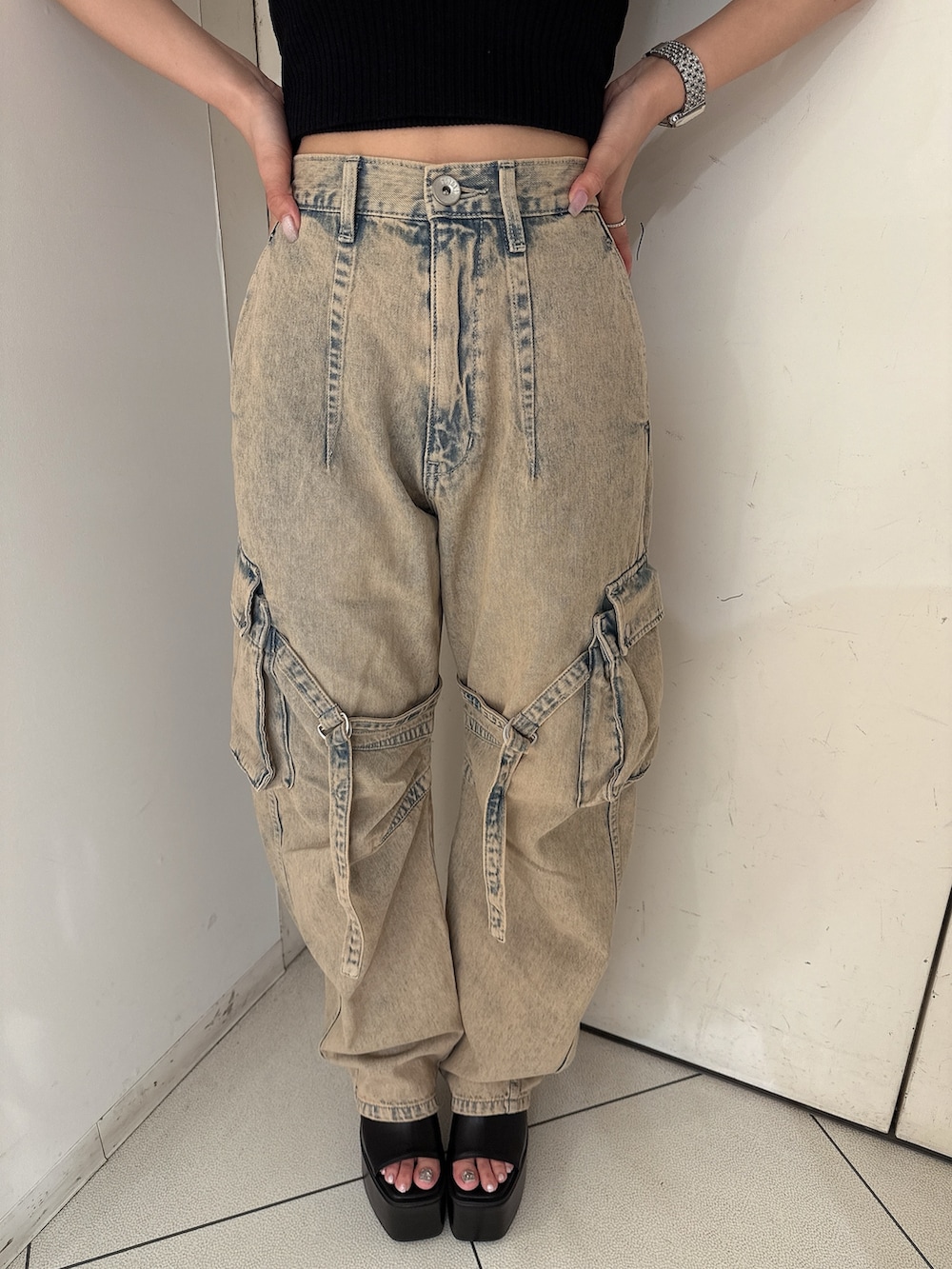 ブラック系のニット/セーター、ブルー系のデニムパンツ、ブラック系のサンダルを着用したレディースの夏コーディネートの8枚目の写真