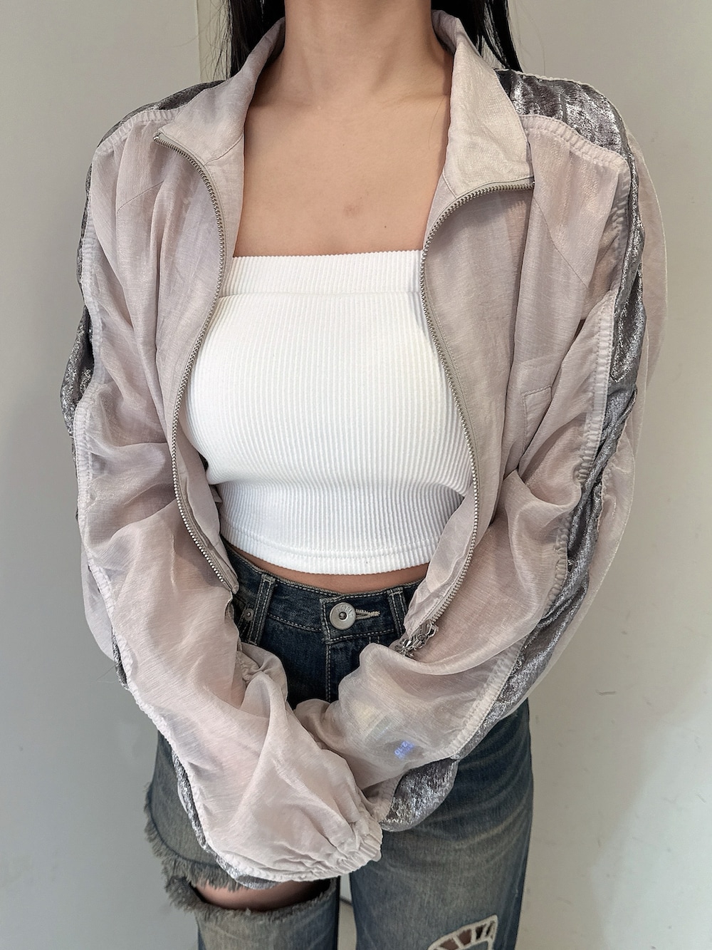 ブルー系のデニムパンツ、ホワイト系のキャミソール、ホワイト系のブルゾンを着用したレディースの春コーディネートの7枚目の写真