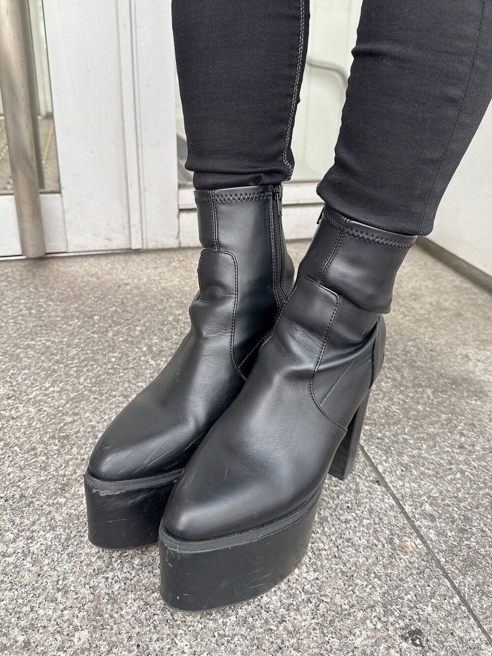 ブラック系のブーツ、ブラック系のスカート、ホワイト系のハンドバッグを着用したレディースの冬コーディネートの10枚目の写真