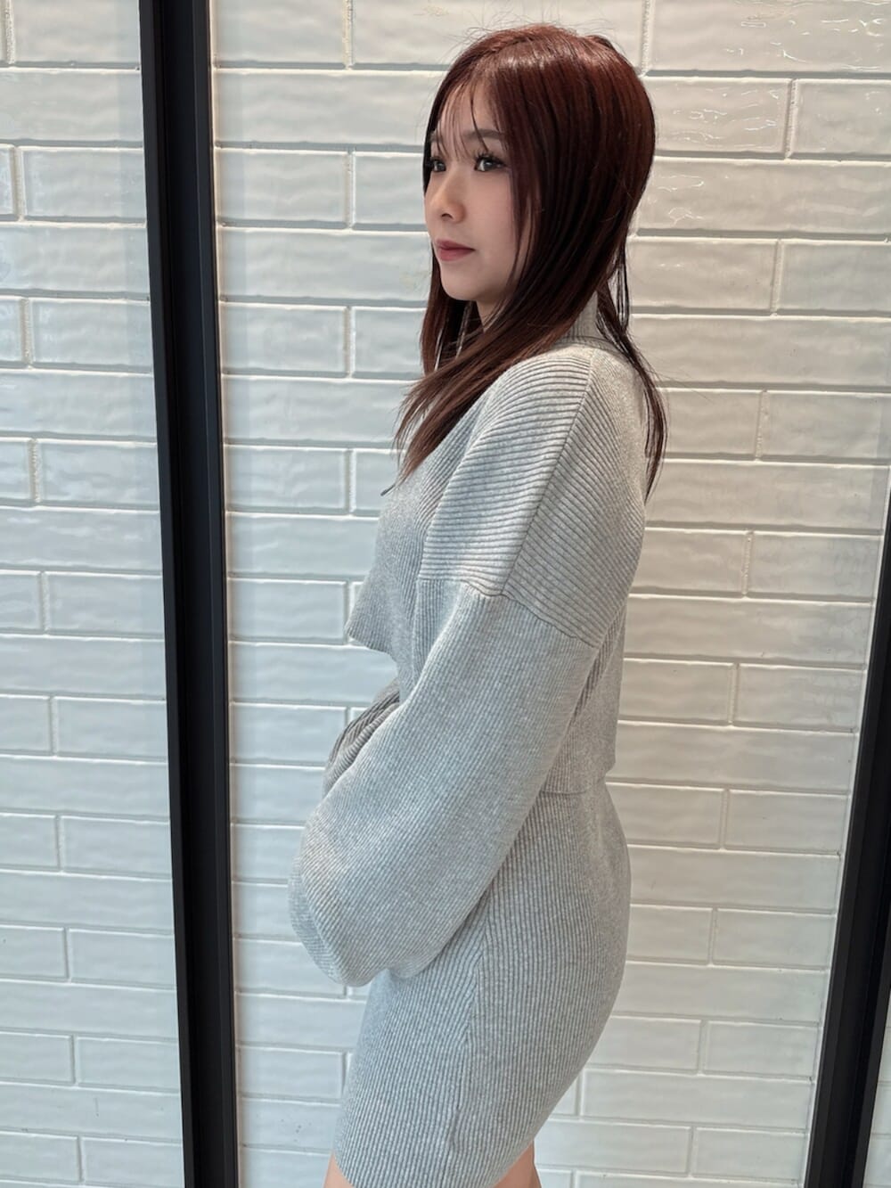 ブラック系のブーツ、グレー系のワンピースを着用したレディースの冬コーディネートの5枚目の写真