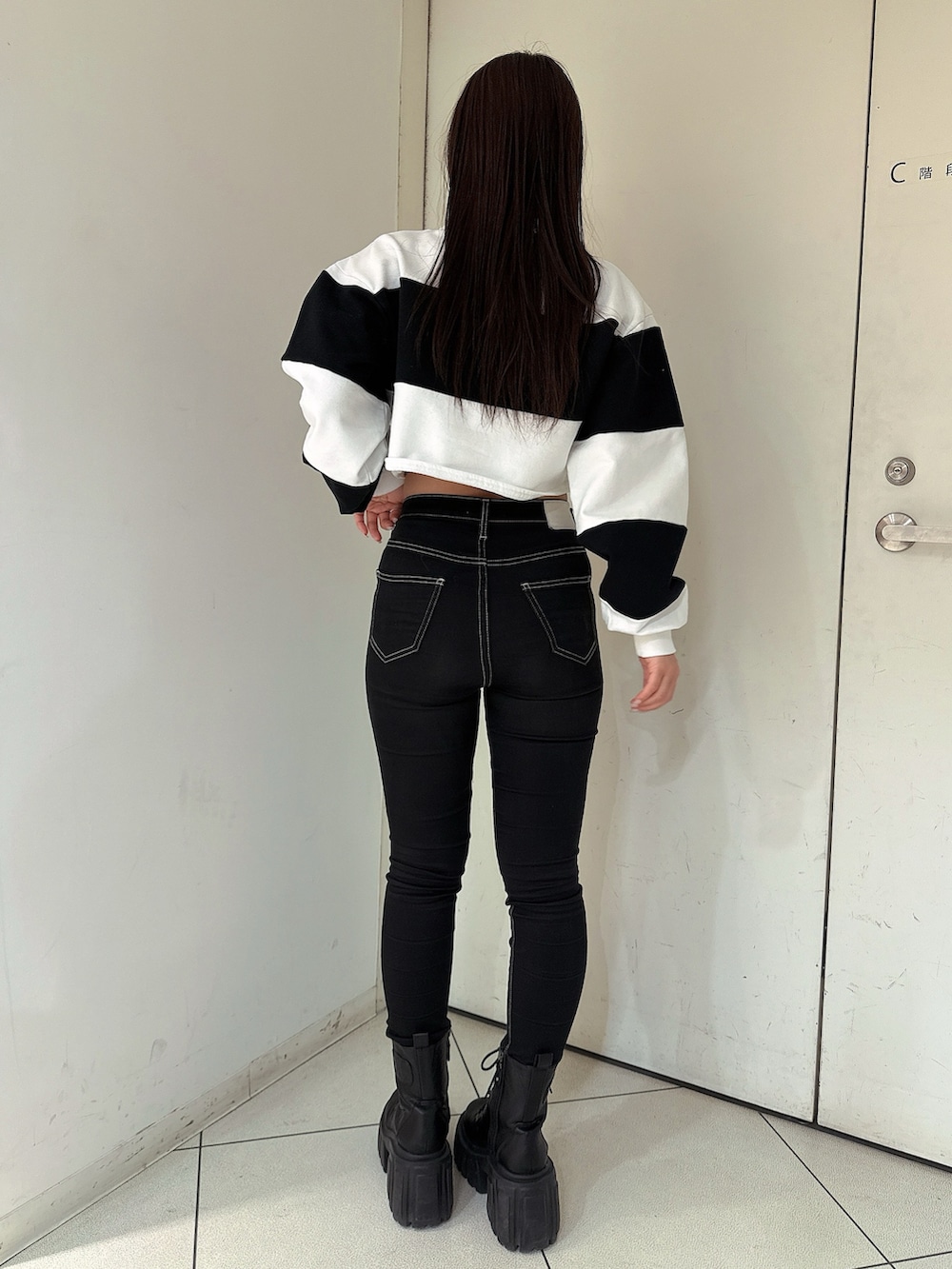 ブラック系のデニムパンツ、ブラック系のブーツ、ホワイト系のTシャツ/カットソーを着用したレディースの冬コーディネートの3枚目の写真