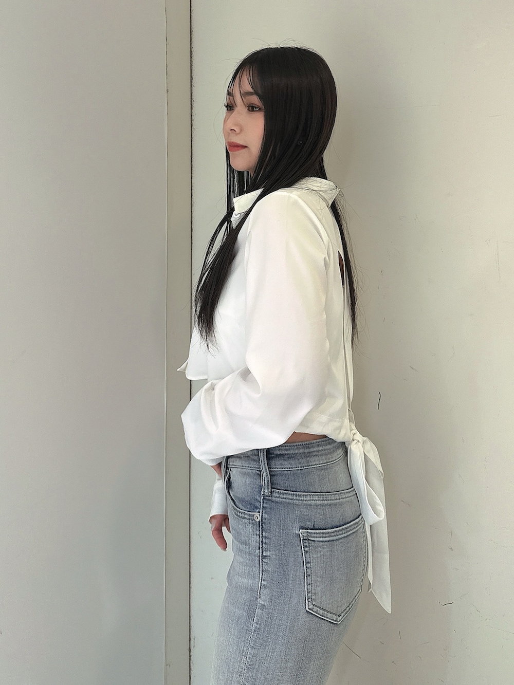 ブルー系のデニムパンツ、ホワイト系のキャミソール、ホワイト系のシャツ/ブラウスを着用したレディースの春コーディネートの5枚目の写真