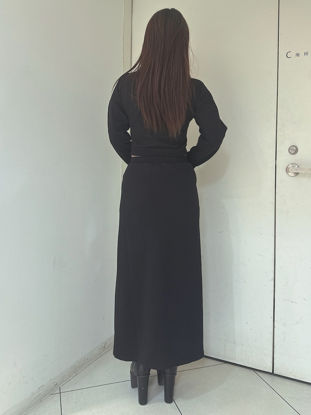 ブラック系のスウェット、ブラック系のスカートを着用したレディースの冬コーディネートの3枚目の写真