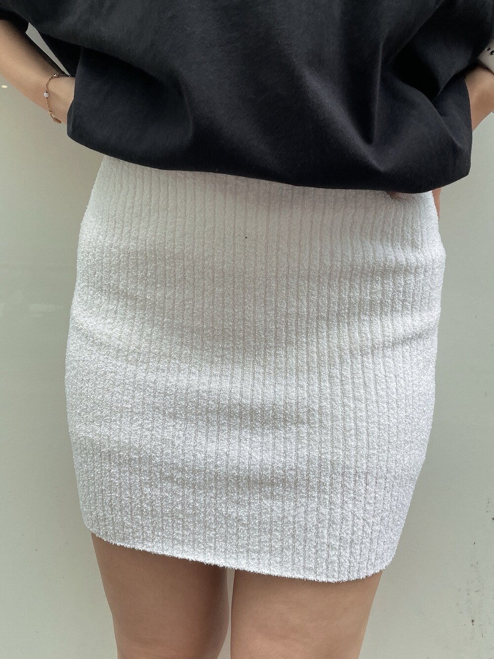 ブラック系のTシャツ/カットソー、ホワイト系のスカート、ホワイト系のサンダルを着用したレディースの春コーディネートの7枚目の写真