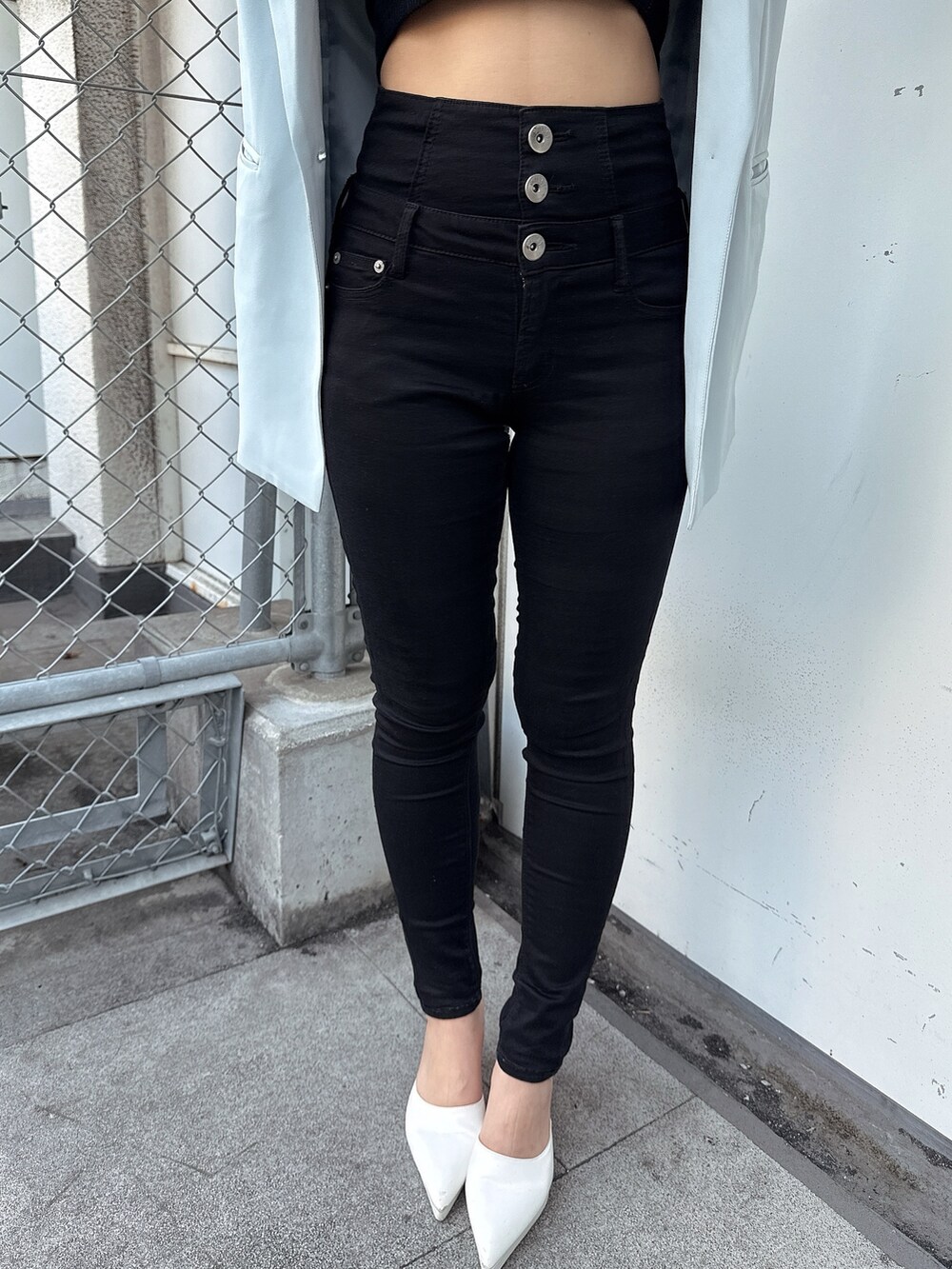 ブラック系のキャミソール、ブラック系のデニムパンツ、ホワイト系のパンプスを着用したレディースの春コーディネートの7枚目の写真