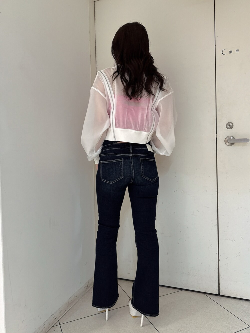 ブルー系のデニムパンツ、ホワイト系のブルゾン、ピンク系のキャミソールを着用したレディースの春コーディネートの3枚目の写真