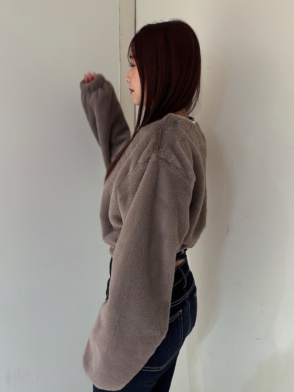 ブラック系のブーツ、ブルー系のデニムパンツ、ベージュ系のTシャツ/カットソーを着用したレディースの秋コーディネートの5枚目の写真