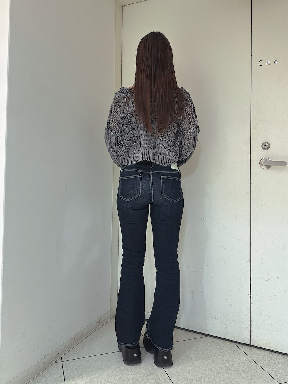 ブルー系のデニムパンツ、ブルー系のニット/セーター、ブラック系のサンダルを着用したレディースの春コーディネートの3枚目の写真