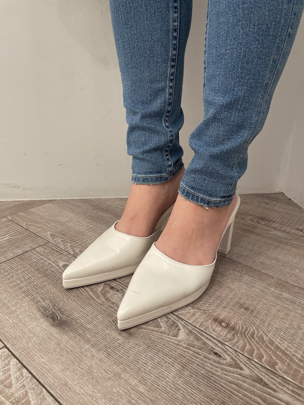 ブラック系のライダースジャケット、ブラック系のデニムパンツ、ホワイト系のハンドバッグを着用したレディースの冬コーディネートの7枚目の写真