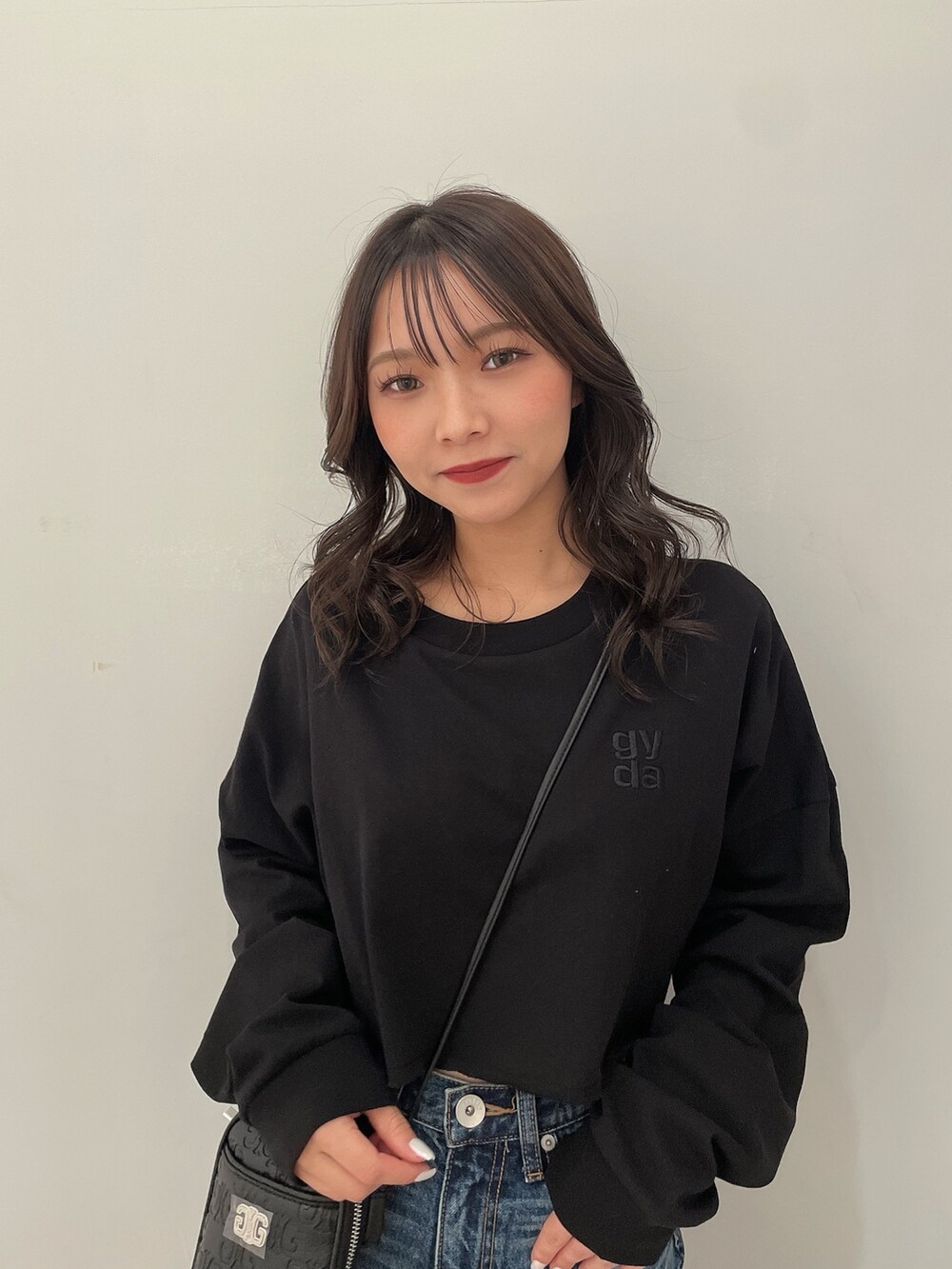 ブラック系のTシャツ/カットソー、ブルー系のデニムパンツ、ブラック系のブーツを着用したレディースの春コーディネートの4枚目の写真