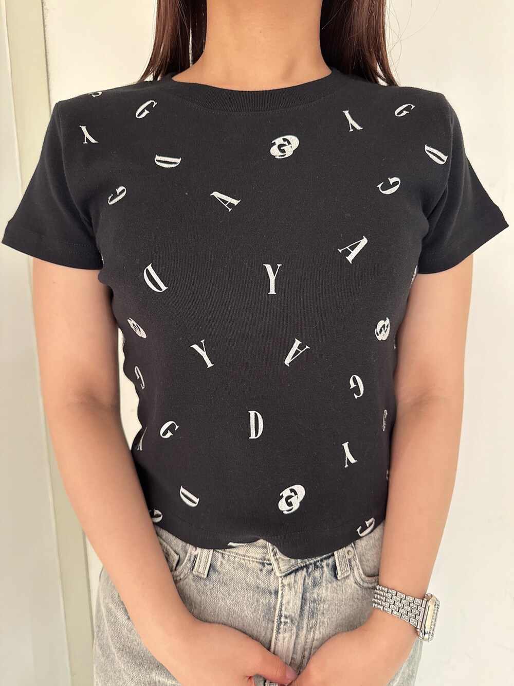 ブラック系のTシャツ/カットソー、ブルー系のデニムパンツ、ブラック系のサンダルを着用したレディースの夏コーディネートの7枚目の写真