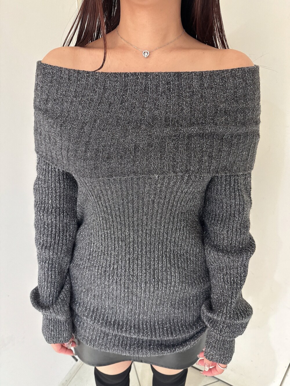 ブラック系のブーツ、ブラック系のスカート、ブラック系のチュニックを着用したレディースの秋コーディネートの7枚目の写真