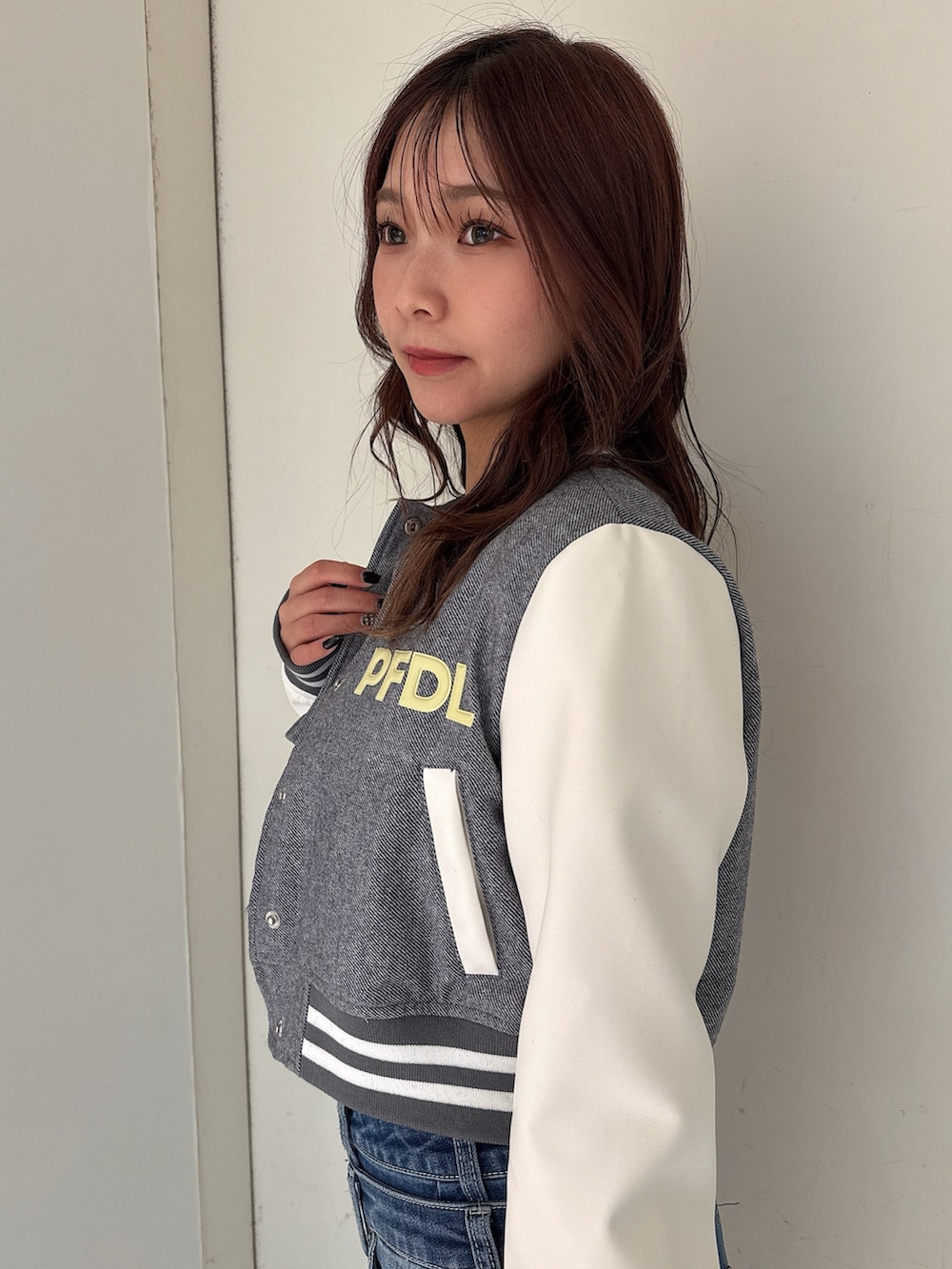 グレー系のニット/セーター、ブルー系のデニムパンツ、ホワイト系のパンプスを着用したレディースの冬コーディネートの5枚目の写真