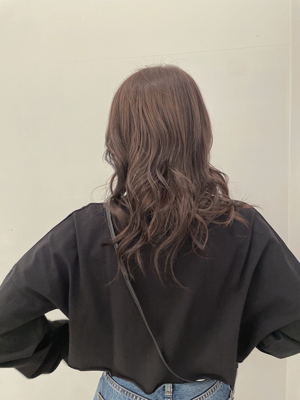 ブラック系のTシャツ/カットソー、ブルー系のデニムパンツ、ブラック系のブーツを着用したレディースの春コーディネートの6枚目の写真