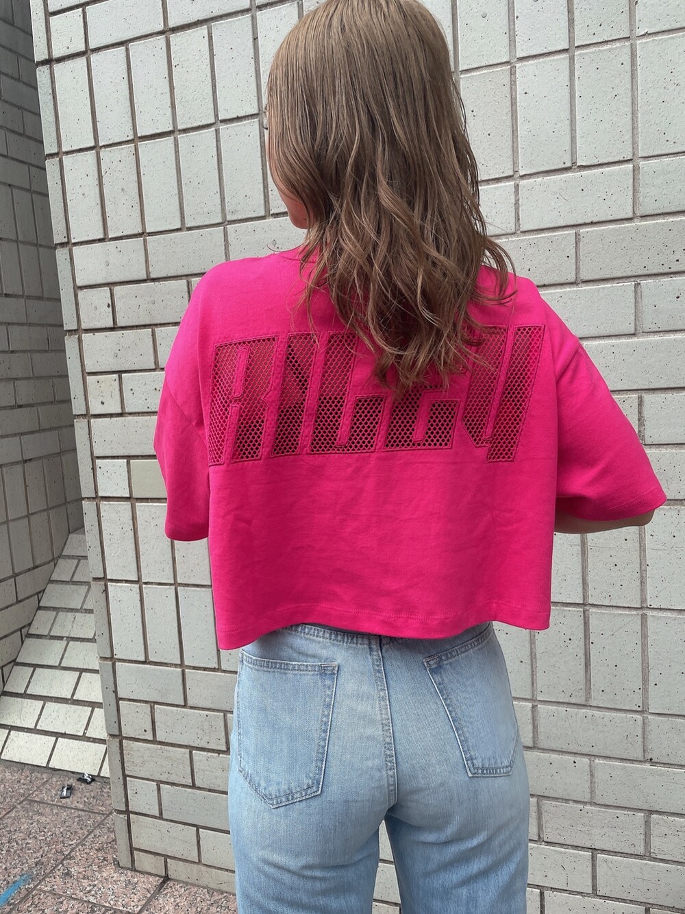 ブルー系のデニムパンツ、ホワイト系のサンダル、ピンク系のTシャツ/カットソーを着用したレディースの夏コーディネートの4枚目の写真