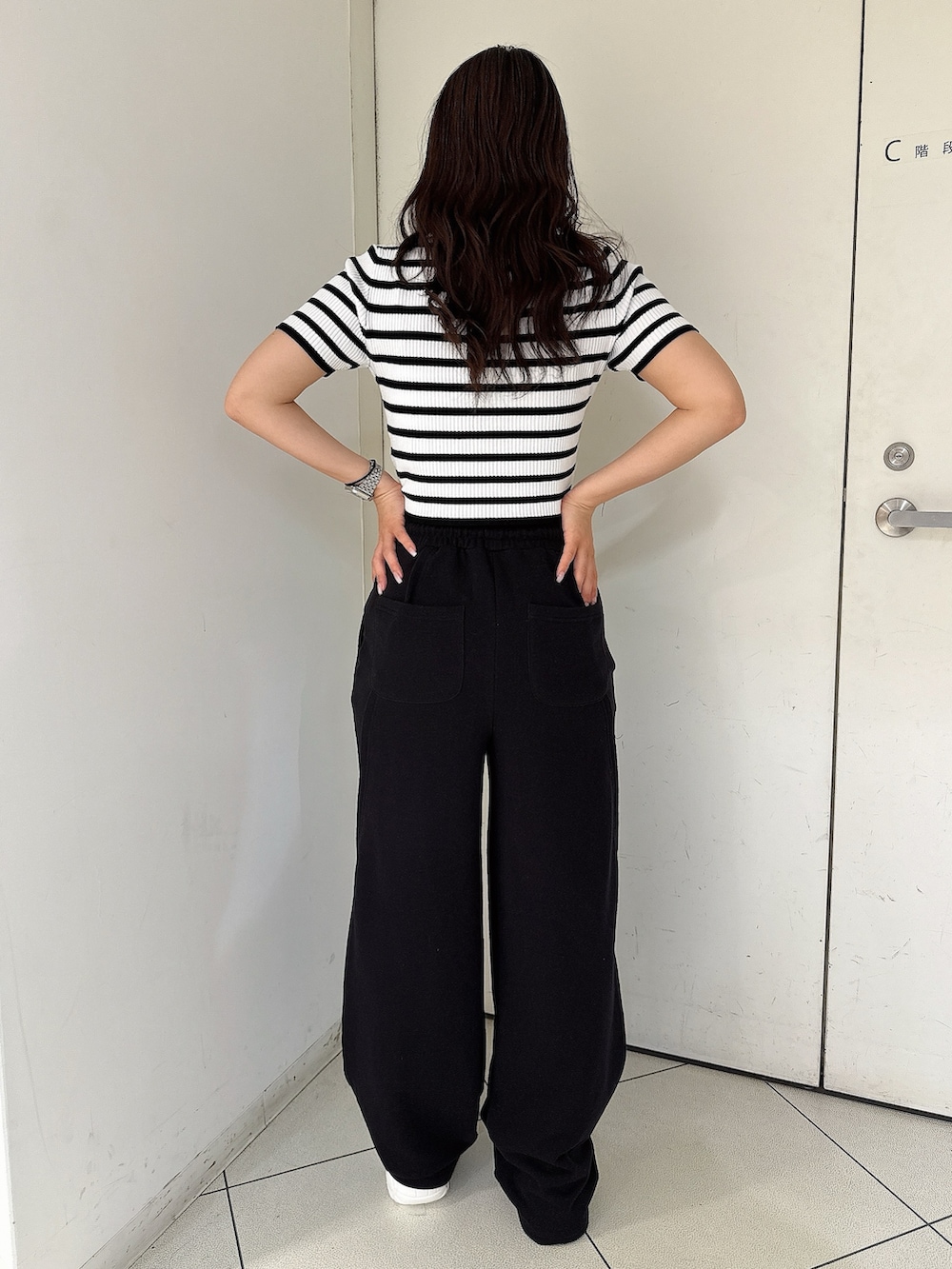 ブラック系のスウェットパンツ、ホワイト系のスニーカー、ブラック系のニット/セーターを着用したレディースの春コーディネートの3枚目の写真