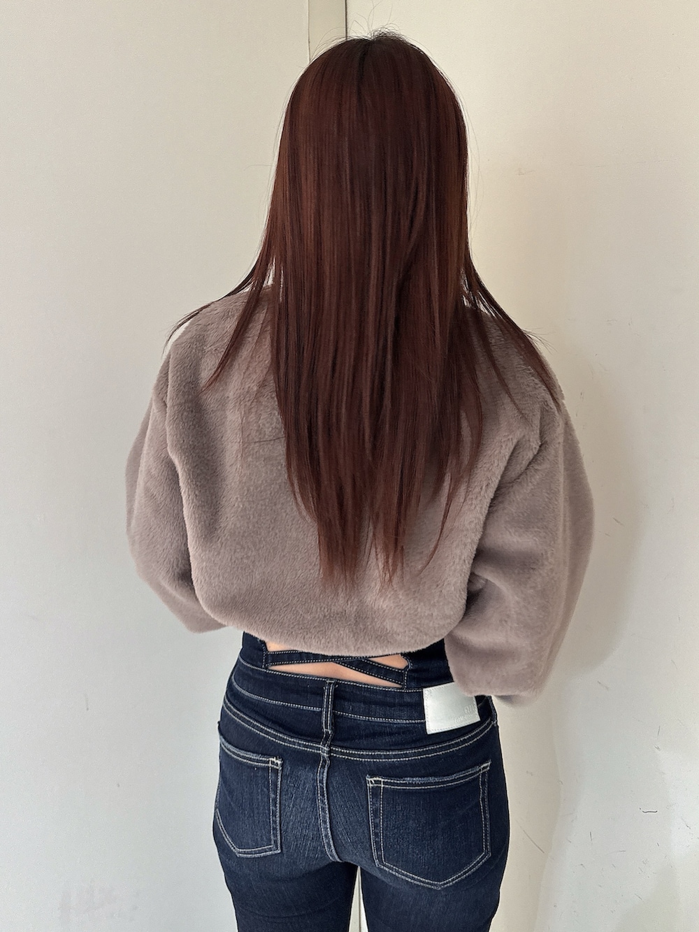 ブラック系のブーツ、ブルー系のデニムパンツ、ベージュ系のTシャツ/カットソーを着用したレディースの秋コーディネートの6枚目の写真