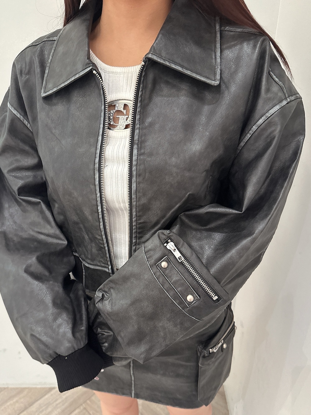 ブラック系のブーツ、ホワイト系のニット/セーター、ブラック系のスカートを着用したレディースの秋コーディネートの7枚目の写真