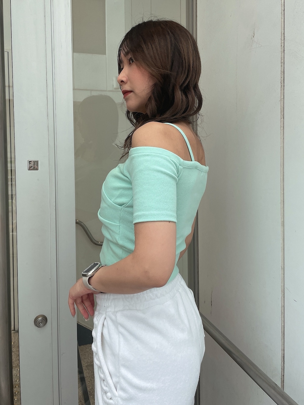 グリーン系のTシャツ/カットソー、ホワイト系のその他パンツ、ホワイト系のサンダルを着用したレディースの春コーディネートの5枚目の写真