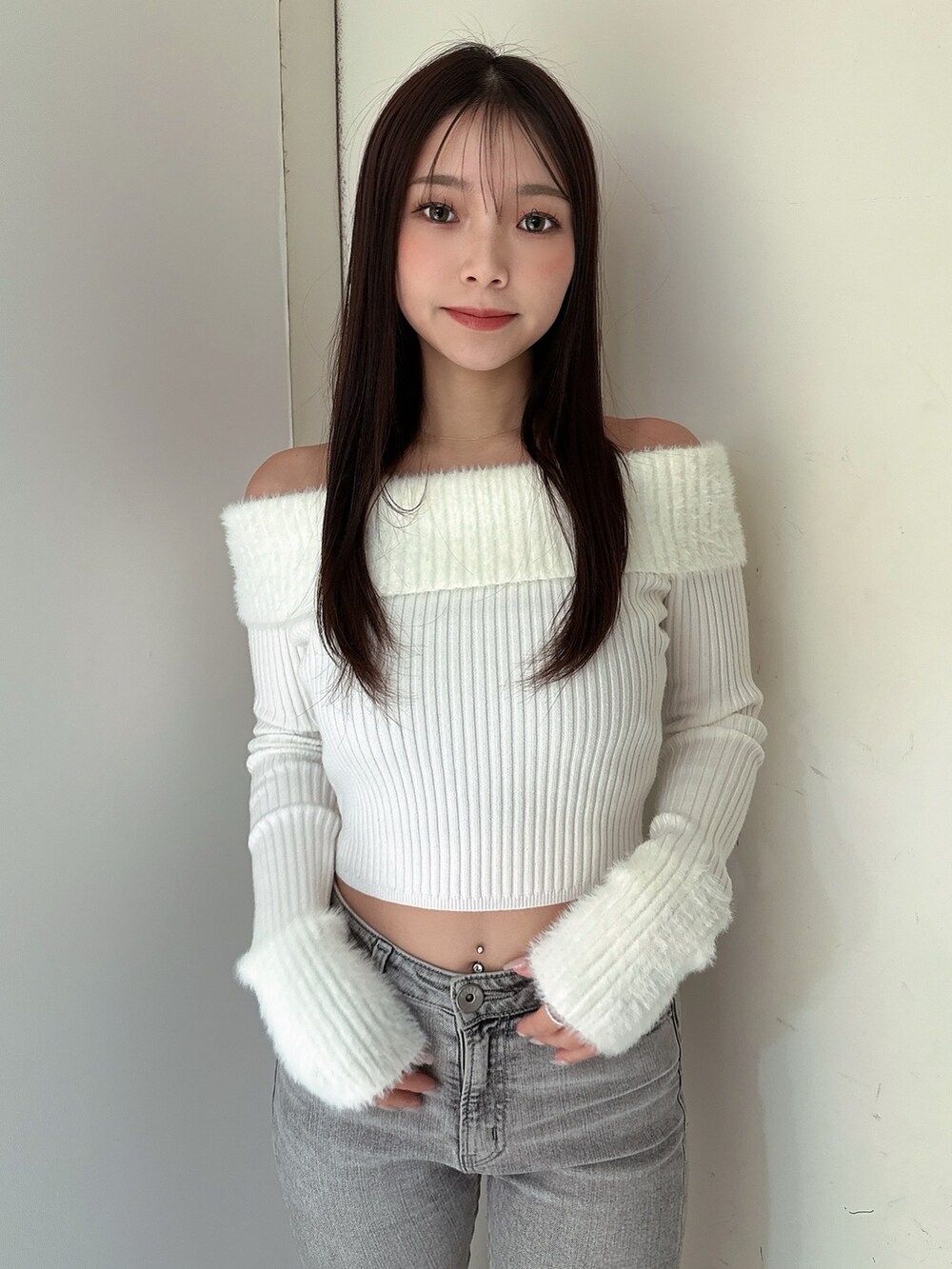 グレー系のデニムパンツ、ブラック系のブーツ、ホワイト系のニット/セーターを着用したレディースの冬コーディネートの4枚目の写真