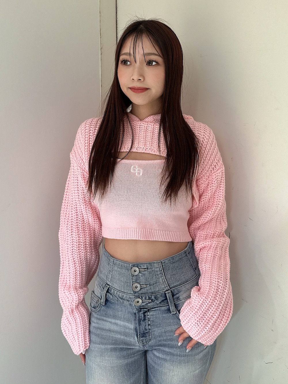 ブルー系のデニムパンツ、ピンク系のニット/セーター、ブラック系のブーツを着用したレディースの冬コーディネートの4枚目の写真