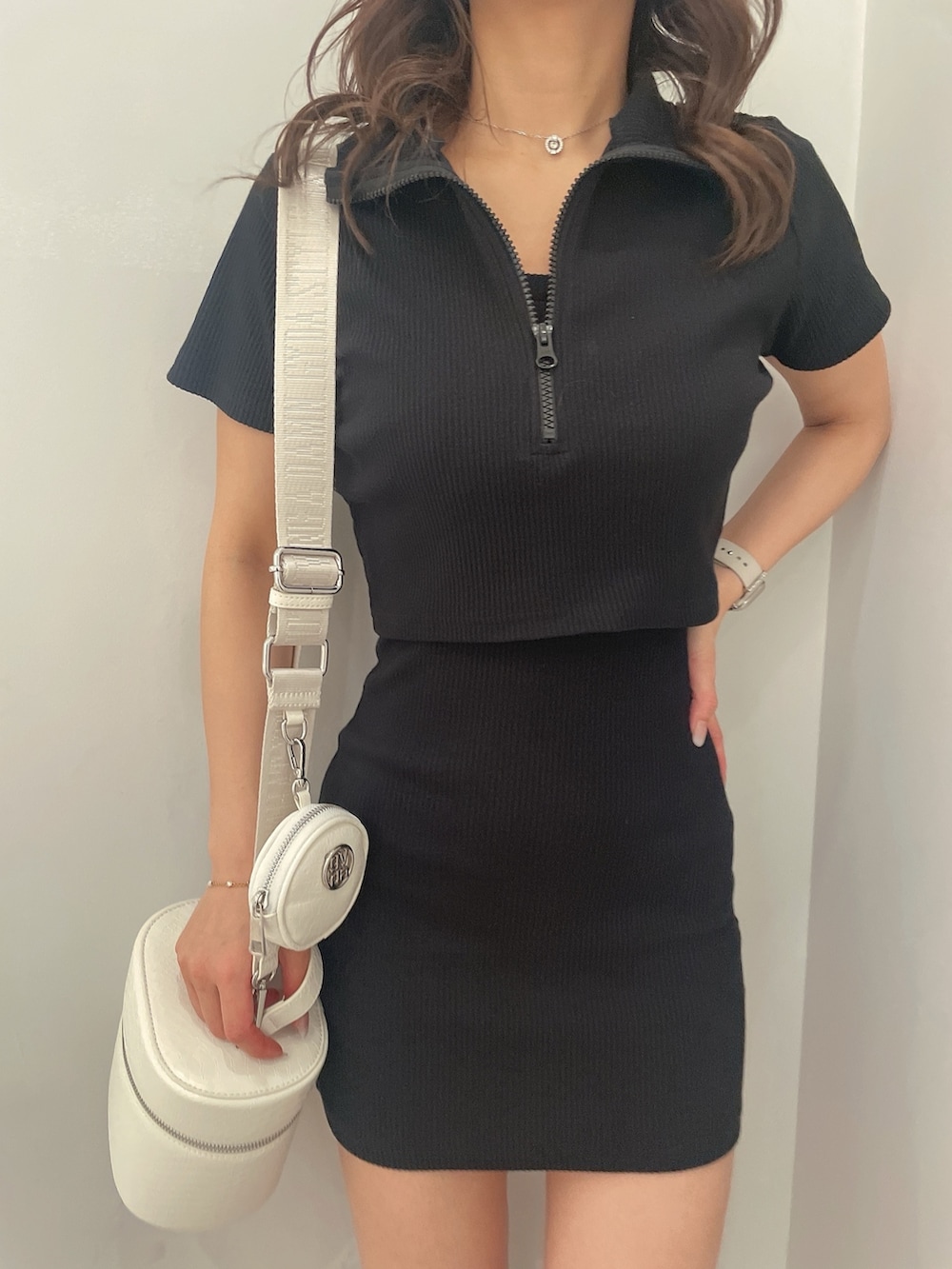 ブラック系のワンピース、ブラック系のハンドバッグ、ホワイト系のブーツを着用したレディースの春コーディネートの7枚目の写真