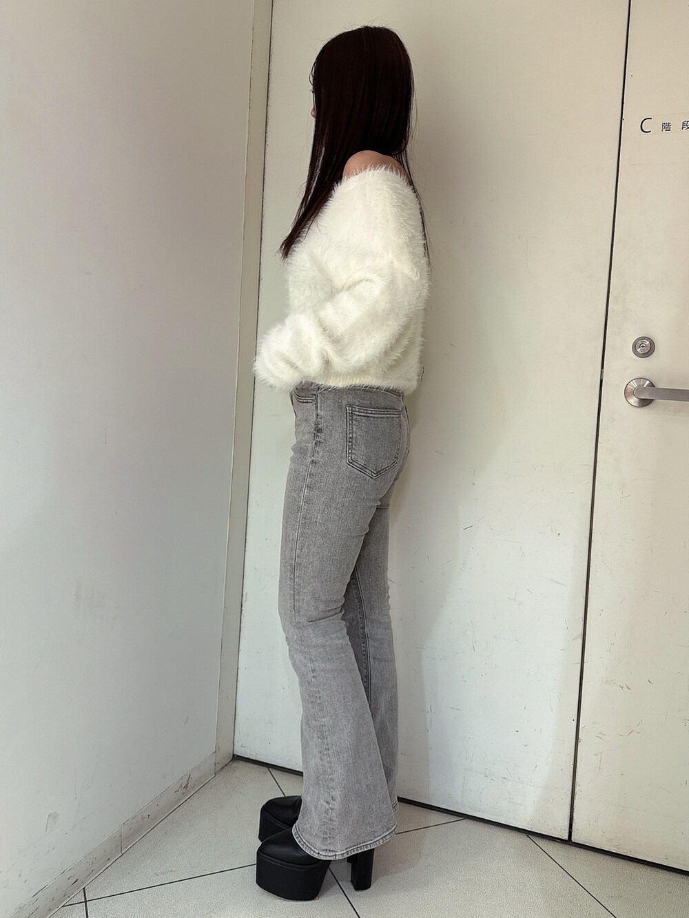 ホワイト系のニット/セーター、グレー系のデニムパンツ、ブラック系のブーツを着用したレディースの冬コーディネートの2枚目の写真