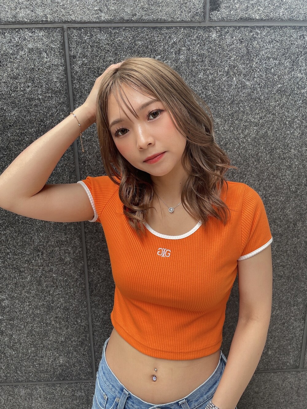 オレンジ系のTシャツ/カットソー、ブルー系のデニムパンツ、ブラック系のチューブトップを着用したレディースの夏コーディネートの3枚目の写真