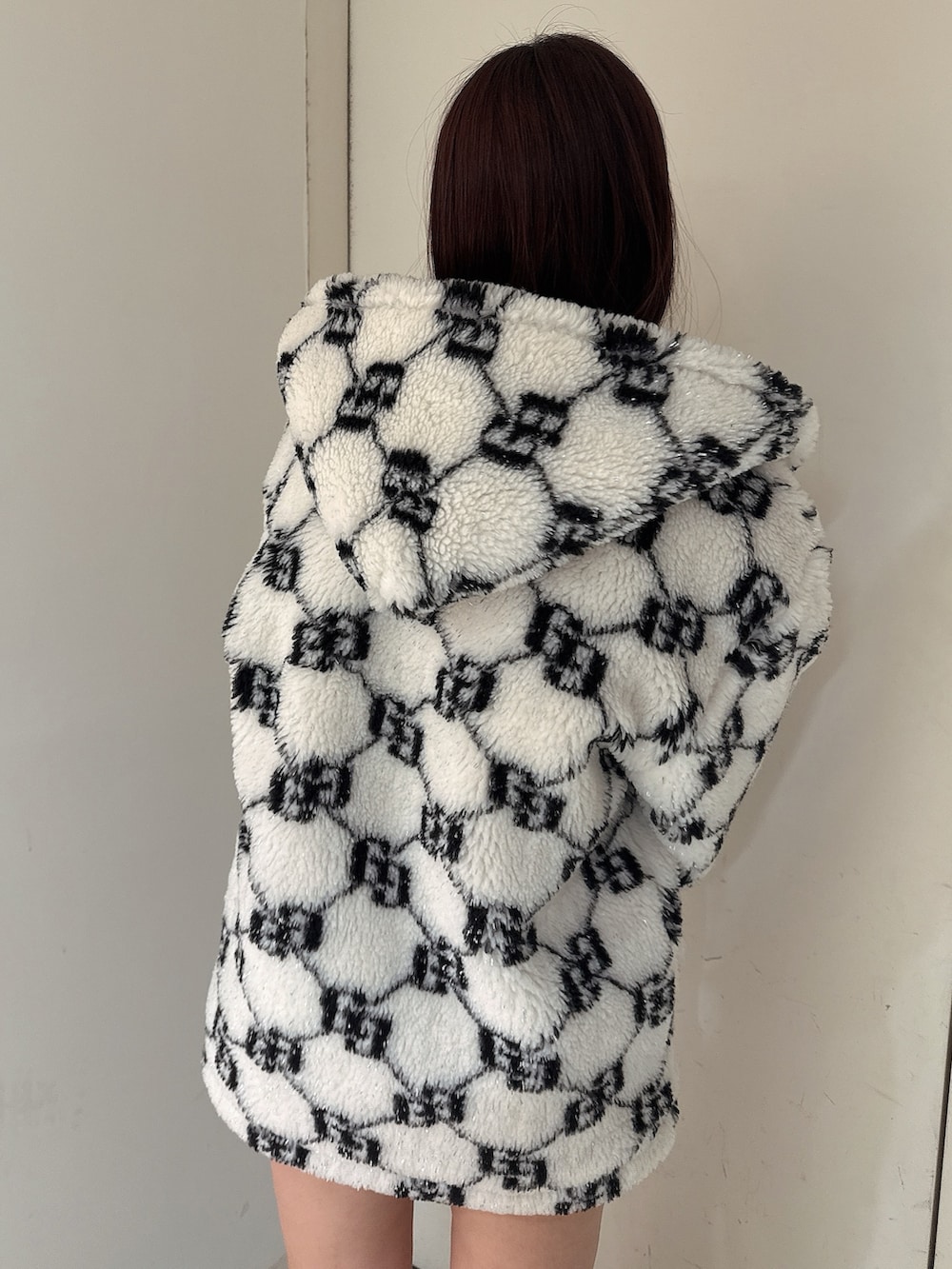 ホワイト系のブルゾン、ブラック系のスカート、ブラック系のブーツを着用したレディースの秋コーディネートの6枚目の写真