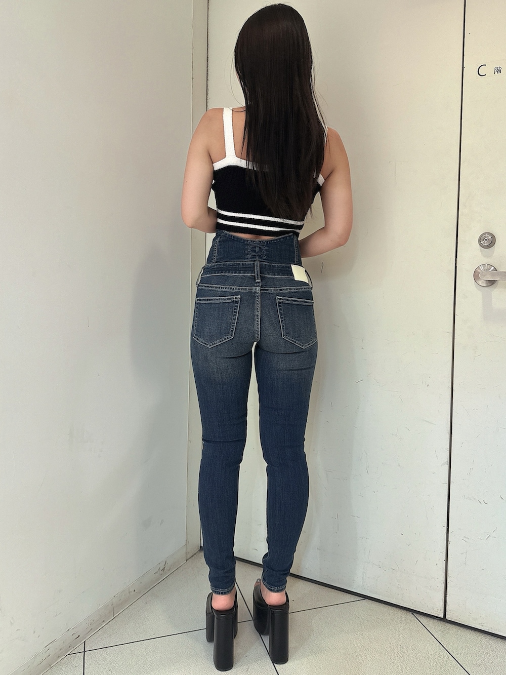 ブルー系のデニムパンツ、ブラック系のキャミソール、ブラック系のサンダルを着用したレディースの春コーディネートの3枚目の写真