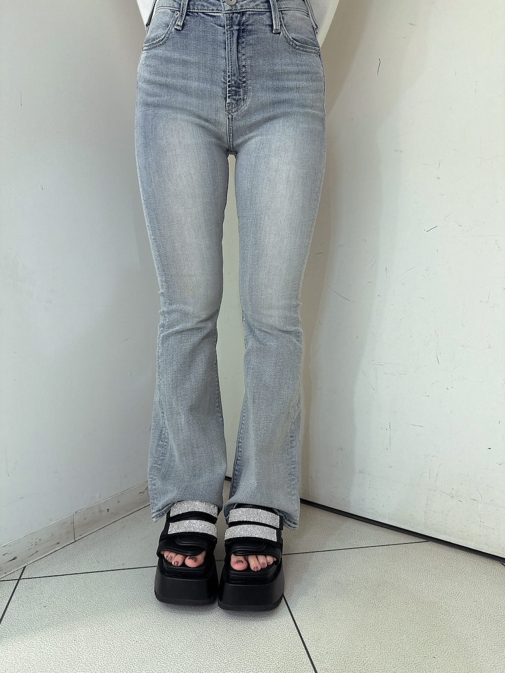 ブルー系のデニムパンツ、ブラック系のサンダル、ホワイト系のカーディガン/ボレロを着用したレディースの春コーディネートの8枚目の写真