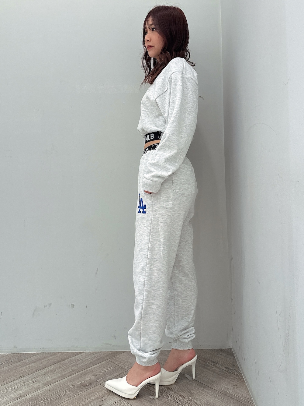 グレー系のスウェットパンツ、グレー系のスウェット、ホワイト系のパンプスを着用したレディースの冬コーディネートの2枚目の写真